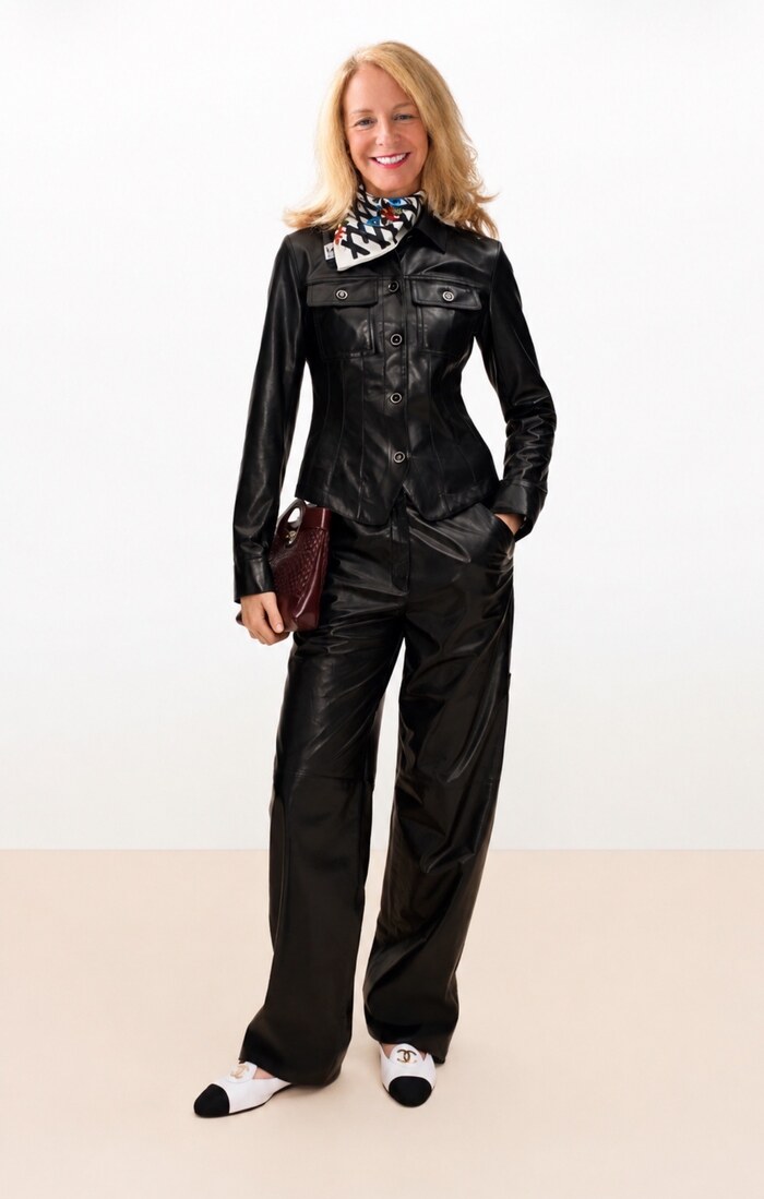 Donna in a black leather outfit with a silk scarf